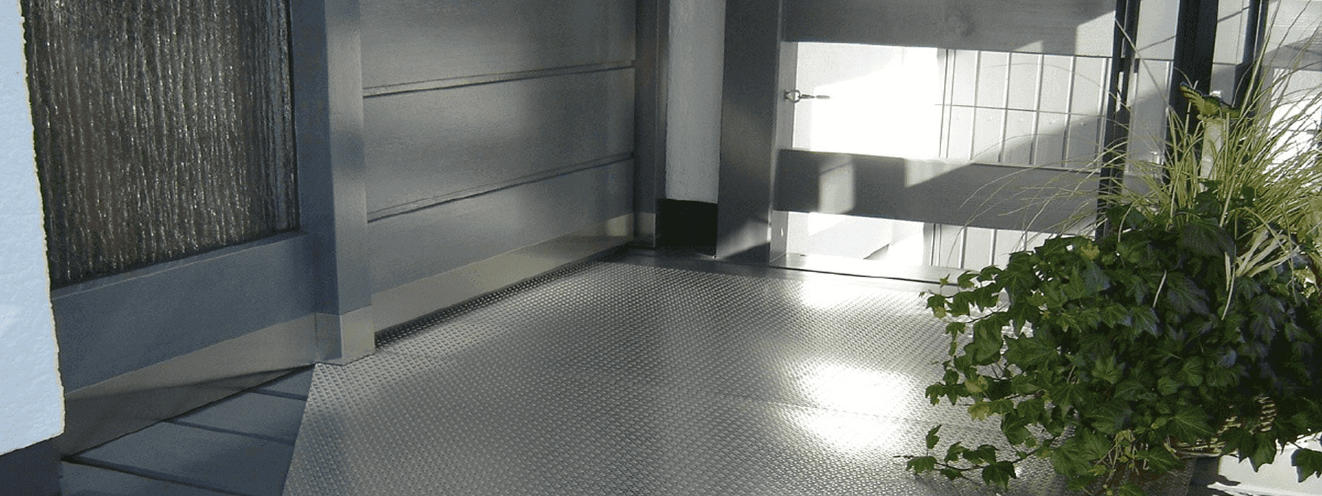 high strength alloy steel hot-rolled checker plates for flooring of a large room, and a large pot of green plants on the ground.